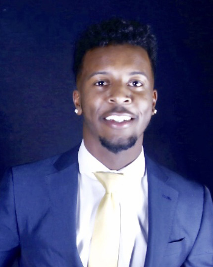 A man in a suit and tie smiling for the camera.